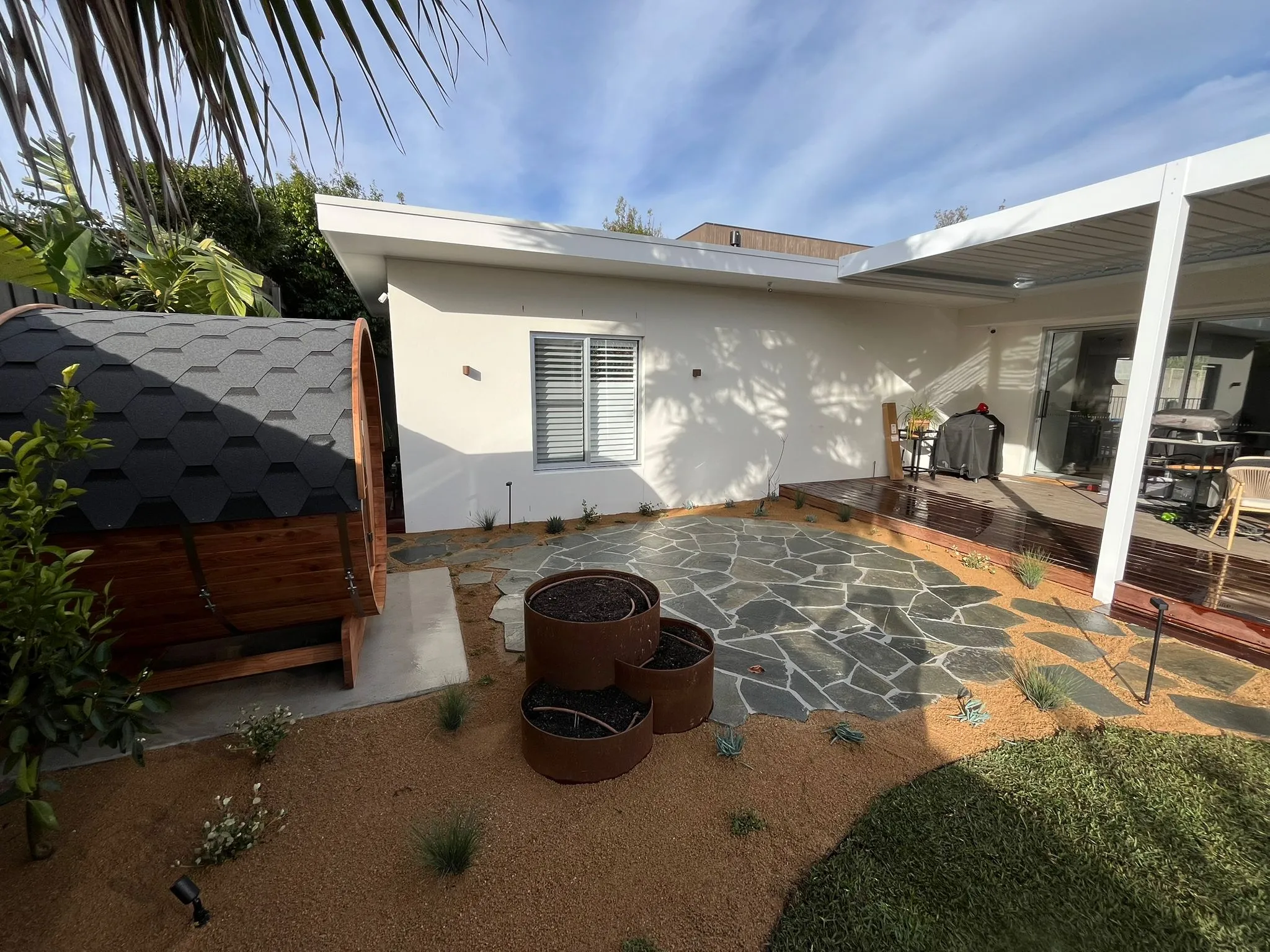 Flagstone paving and barrel sauna in rear garden